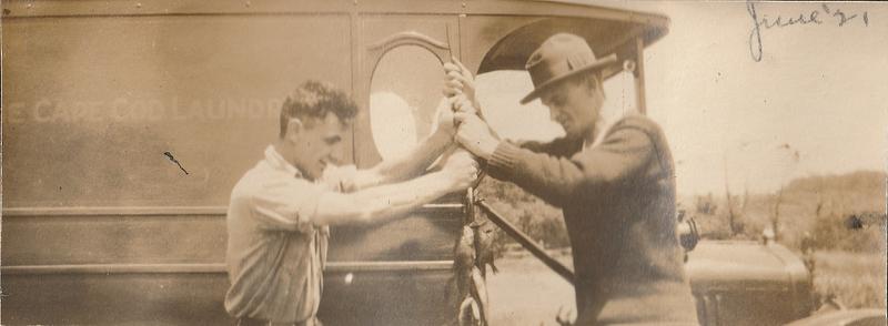 Andy Grade and Arthur S. Graham, holding fish in front of a Cape Cod Laundry truck, West Yarmouth, Mass.