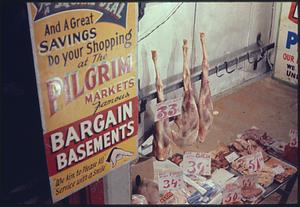 "Pilgrim Markets Bargain Basements" sign next to meat for sale