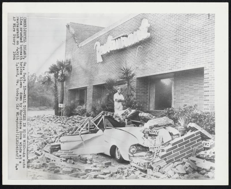 Wall Topples in High Wind--An auto lies crushed beneath bricks blown down by Hurricane Dora winds at a restaurant on Jekyll Island, Ga. today.