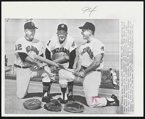 What Positions Will They Play--Arriving in camp early to workout with the pitchers and catchers, Gene Green (left) and Woodie Held (right) were wondering what positions they will play with this year's Cleveland Indians. Birdie Tebbetts (center), new Indian manager, says they can play outfield, infield or catcher but what he is mainly interested in "can they hit".