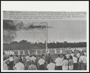 Klan Rally--Knights of the Ku Klux Klan march in a circle around a 50 ft. burning cross Sunday as approximately 2,500 watch the closing ceremony of the rally near Trenton, N.C.