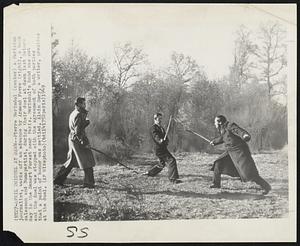 Duel At Dawn--Pierre Merindol (center) a Parisian journalist, wards off an advance by Armand Fevre (right), a book salesman and Bonapartist, during their duel at dawn last Saturday in the Senart Forest near Paris. Merindol's hand was cut and the duel was stopped with the agreement of both parties that a point of honor was settled. Alain Sory, a writer, presides at the duel.