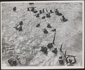 Infantrymen wade from ships to shore during the invasion of Morotai Island