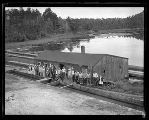 A group of people standing by a fish hatchery