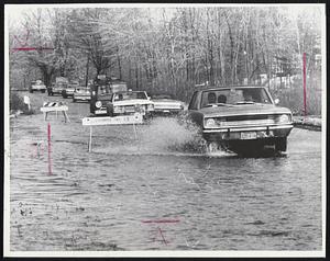 Common Sight throughout Eastern Massachusetts yesterday as heavy rain and melting snow left many highways awash. Cars are entering a hubcap-deep section of Rte. 139 in Staughton.