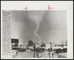 Conway, Ark. – Funnel Of Fury – A white tornado funnel snakes against a background of black clouds here Saturday night before the tornado swooped down on this central Arkansas town twice., killing six persons and injuring more than 100. Young men in the foreground run for automobiles to seek safety. Bill Allbright, an amateur photographer and a student at Hendrix College, snapped this picture at dusk.