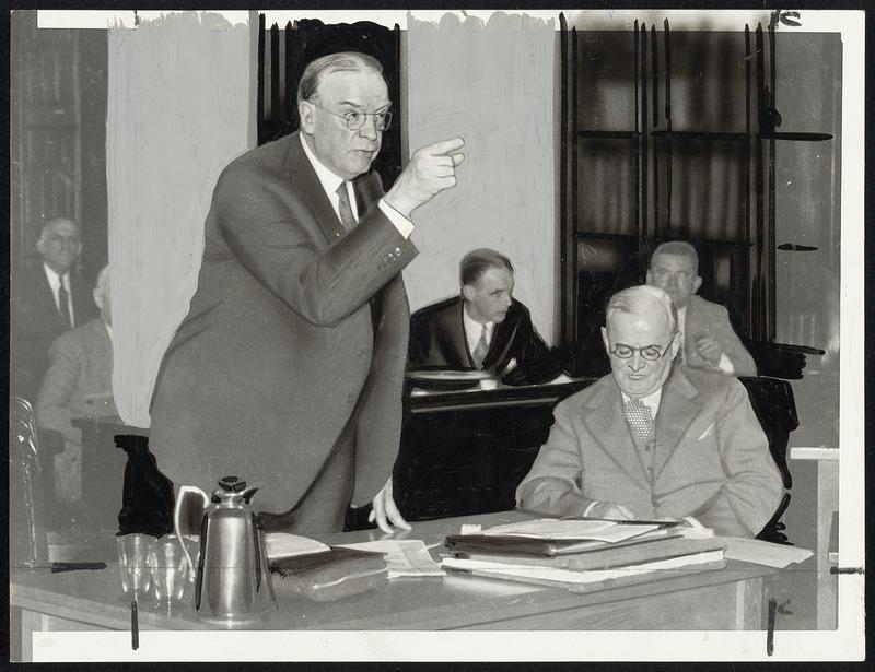 Mayor Mansfield points an accusing finger toward the Boston finance commission during yesterday's stormy session in which he vehemently denounced the members with the exception of the chairman. The mayor's secretary, Joseph F. Mellyn, is seated at the right.