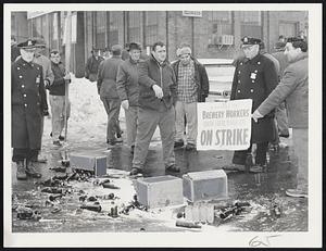 Strikers, Teamsters Clash-Broken beer cases littered Rutherford avenue, Charlestown ,after 150 Brewery Workers Local 8 members attempted to halt passage of trucks driven by Teamsters Union Local 25. Four were hurt in battle at O’Brien Distributing Co. and two arrested for trespassing.