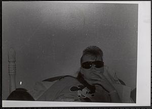 Young woman lying on bed with sunglasses