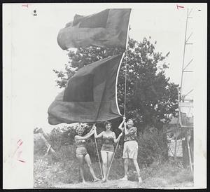 Veteran Weatherman Alpheus W. Drinkwater of Manteo, N. C., raises the storm signal flags of Hurricane Connie. Watching him are Phyllis Freshwater of Beaver Dam, Pa., and Judy Walker of Charlotte, N.C.