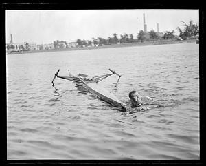 A person in the water next to a scull