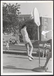 Young man hanging on a basketball rim
