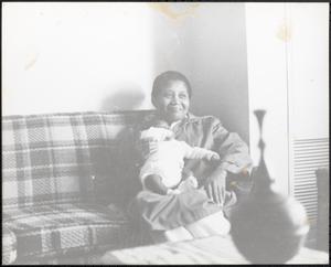 Woman holding a baby on a couch