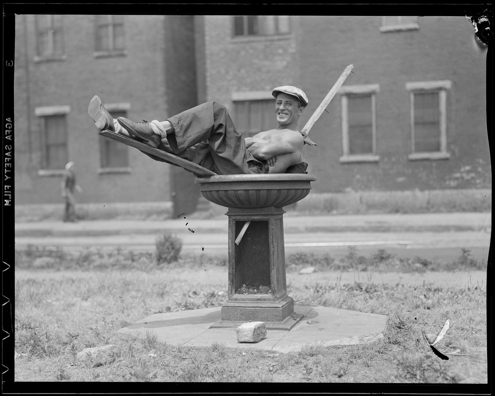 Man cooling off in bird bath on hot day