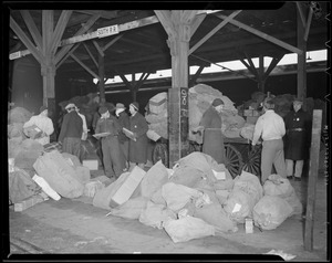 Loading and unloading mail from trains at South Station during Christmas rush