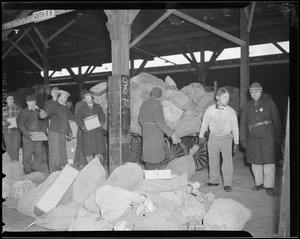 Loading and unloading mail from trains at South Station during Christmas rush