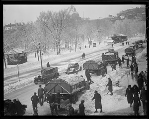 Men shoveling snow into trucks