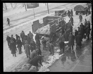 Men shoveling snow into trucks