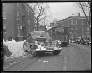 Car and trolley on snow-narrowed streets