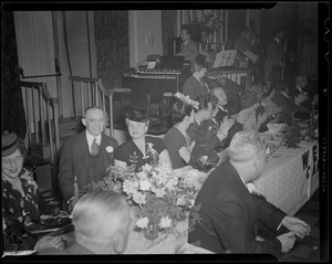 Man signs program of events at dinner at Hotel Avery for Carter Hotels