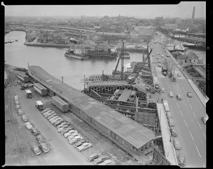 Aerial views, overpass harbor, old "Charlestown" bridge. (Shows Warren Avenue Bridge and Yard 12, behind North Station. View: northwest, lighter at work in Charles River building pier support for North East Express Way. Millers River, left; Bunker Hill Monument, right.)