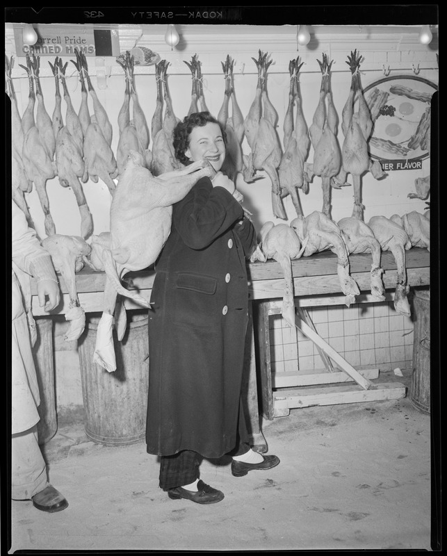 Woman carries Thanksgiving turkey at Thresher & Kelley Market, Faneuil Hall
