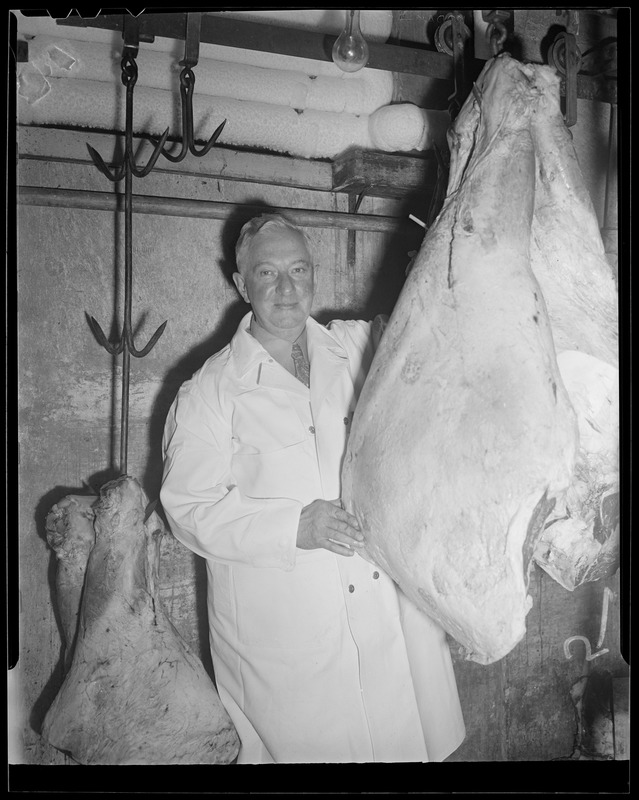 Butcher examines beef in cold room