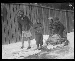 Black kids bringing coal home on sled, South End