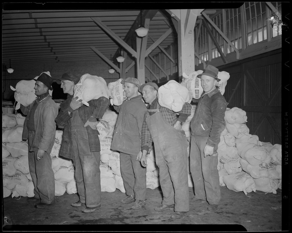 Men carrying bags of turnips at the market terminal