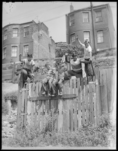 Five boys atop fence