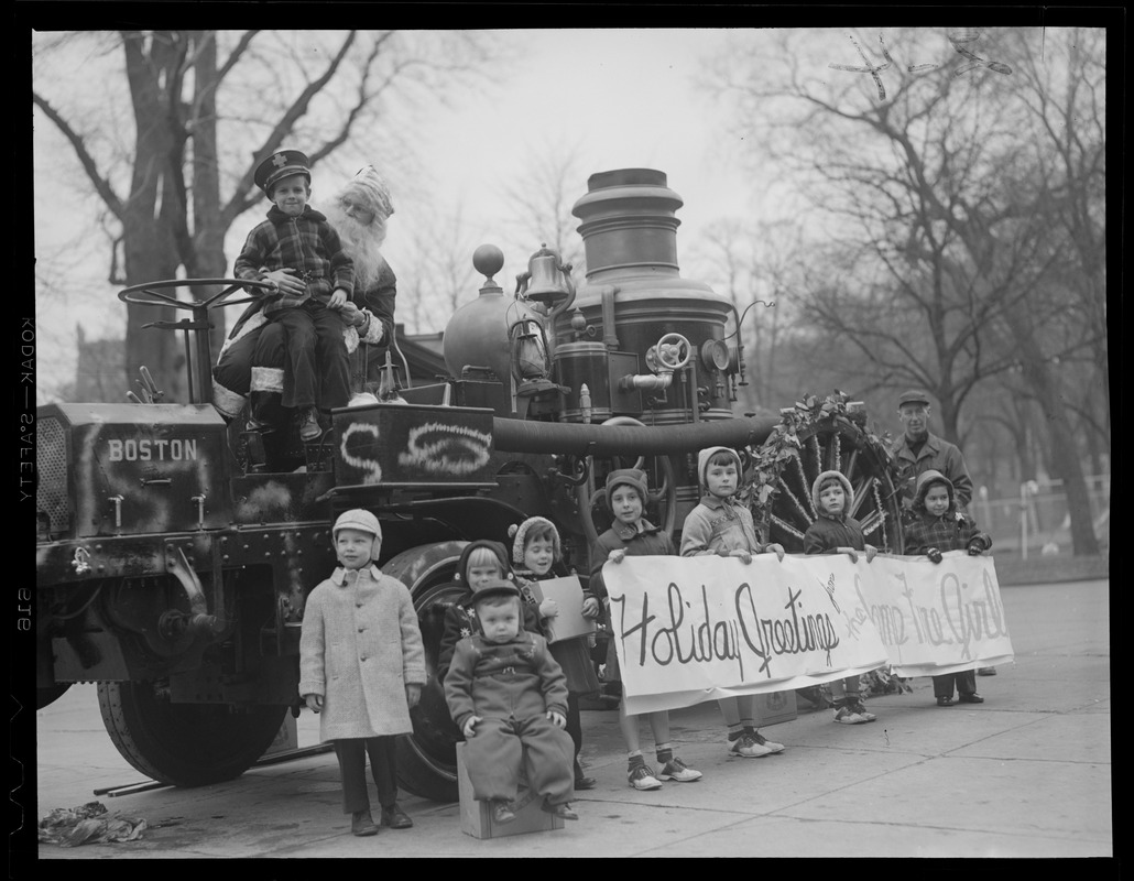 Children pose with steam fire engine decorated for Christmas, on Common