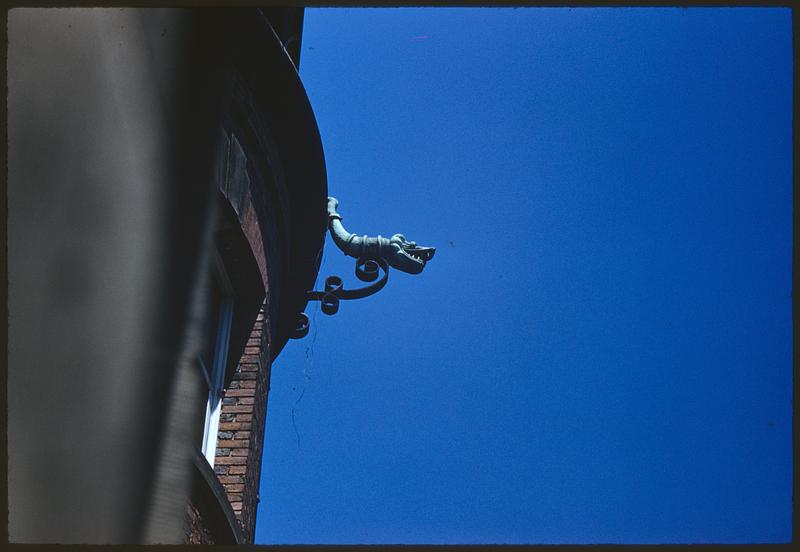 Stylized figurehead on corner of building, possibly drainpipe