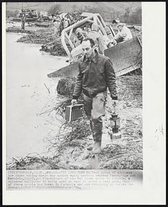 The Long Trek Back--A group of evacuees are shown making their way across muddy terrain between Fernbridge and Eerndale, Calif., as floodwaters of the Eel river start to subside. A stranded bulldozer is being used at rear to cross a deep pool. Most of these people had homes in Ferndale and are returning to survey the damage.
