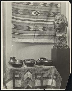 Progress in Southwestern handicraft at the Copley Galleries under the auspices of the Mass. Branch of the Eastern Assn. of Indian affairs. In the photo may be seen examples of Pueblo Pottery & Navaho Rugo. The bronze head of the N. American Indian was speculated by Cyrus E Dallin noted sculptor. Indian Art