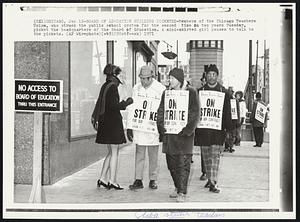 Board of Education Building Picketed-Members of the Chicago Teachers Union, who struck the public school system for the second time in two years Tuesday, picket the headquarters of the Board of Education. A mini-skirted girl pauses to talk to the pickets.