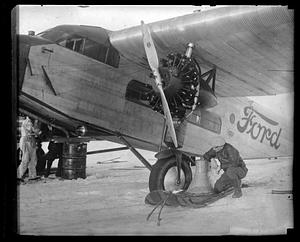 A man looking at the wheel of a Ford's Trimotor