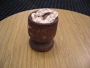 Wooden mortar with stone and paper
