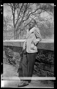 A man leans against a stone wall