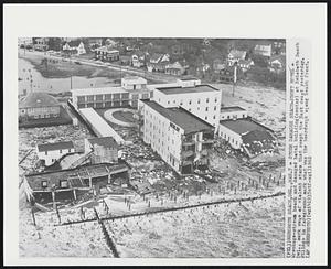 Storm Damages Beach-Front Hotel - Wreckage-strewn beach and damaged hotel building (center) at Rehoboth Beach Del., mark wake of violent storm that swept the East coast yesterday. Pilings in foreground mark what was the boardwalk along beach front.