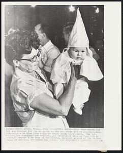 Little Rebel-- This four-month-old tot was dressed for the occasion as she was shown off to photographers attending a Klu Klux Klan rally at Cross Roads last night. The tot. wearing the familiar Klan uniform, was identified only as "the little rebel." Robert M. Shelton of Tuscaloosa, imperial wizard of the United Klans of America, addressed the rally.