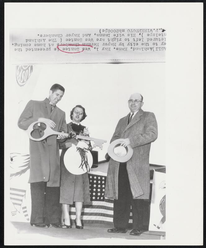 Ashland, Kans. - Wes Santee is presented the [k]ey to the city by Mayor Herman Chambers at home coming. [P]ictured left to right are Wes Santee (The Ashland [A]ntelope), his wife Danna, and Mayor Chambers