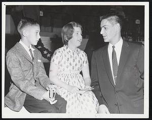 Joan Deveney, 9, of Swampscott learns first-hand what it feels like to have the likes of Maurice Richard come at you with the puck. Terry Sawchuk, Bruins' goalie, is giving her the answer.