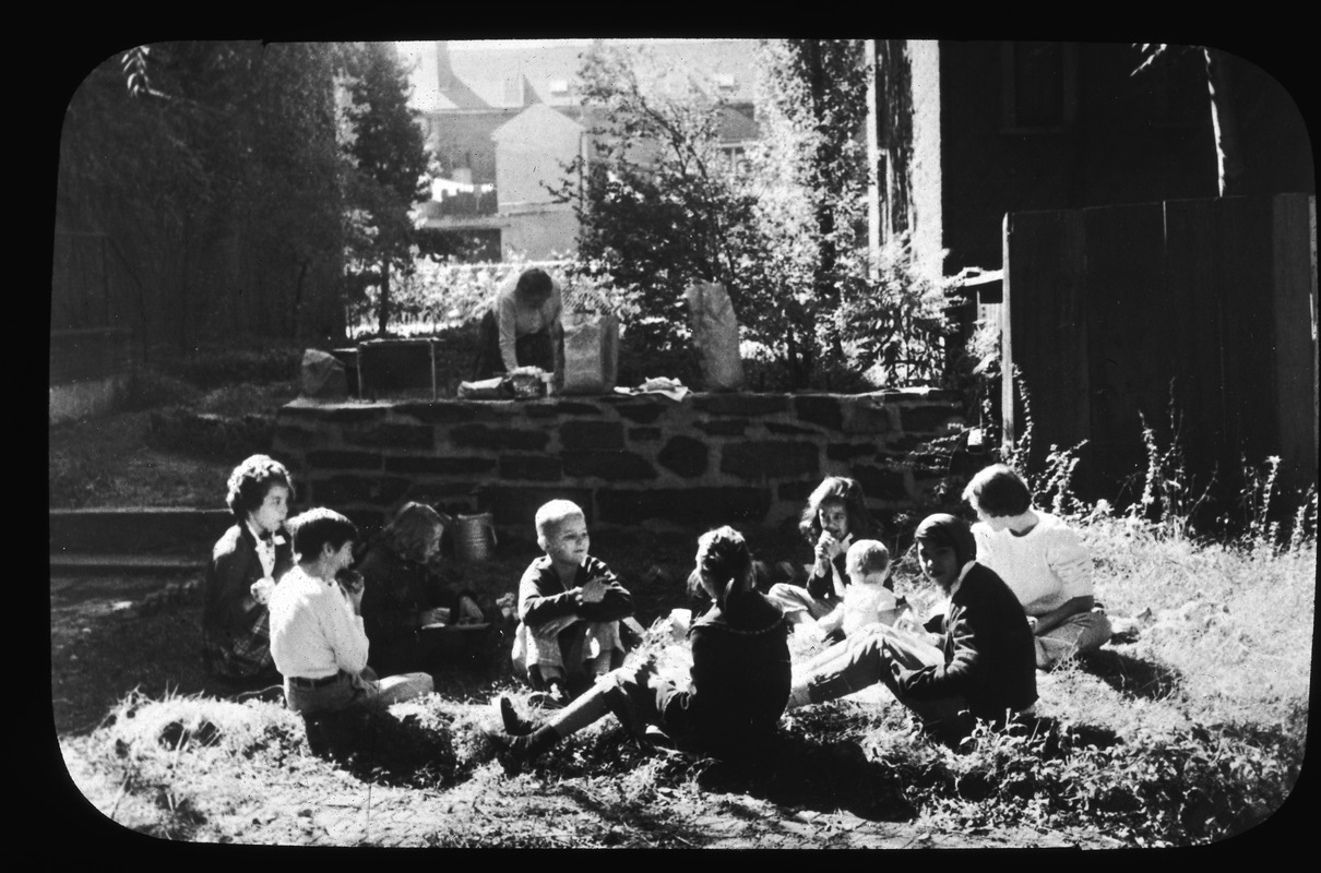 Back yard picnic, St. John's Girls' Choir, plus a couple of younger brothers, enjoy outdoor lunch on grass of Forest Garden, October 6, 1956