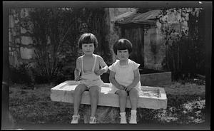 Two children sitting in garden