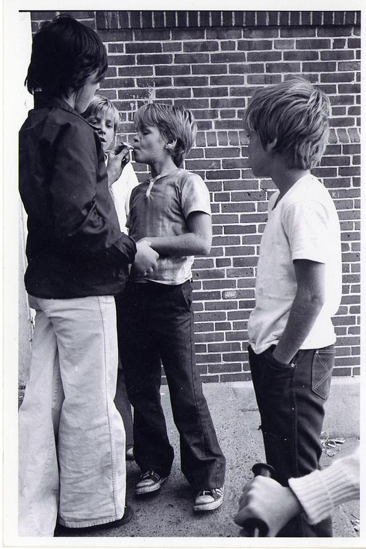 Boy smoking a cigarette while other boys watch