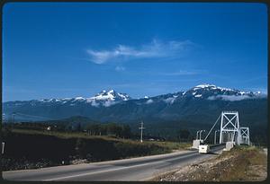 Road and Revelstoke Suspension Bridge with hills and mountains in background, Revelstoke, British Columbia