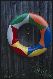 Toy flotation ring hanging on wooden fence