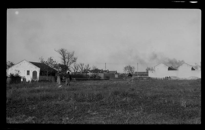 Buildings in a field with two people in foreground