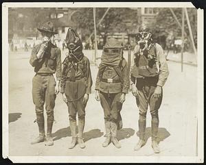 Boy Scouts demonstrate uses of Gas-Masks at Union Square Park. Four Boy Scouts wearing different types of gas-masks. The boys realistically went through their drills and manoeuvres and won applause from the great crowd gathered about the space in the park where they exhibited.