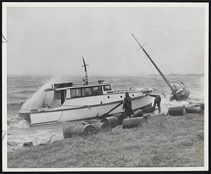 During Height of Storm which lashed Massachusetts coastline Nov. 7, rescue workers are seen (above) attempting to free a small cabin cruiser driven aground on Malibu Beach, South Boston. Cruiser and nearby sailboat were ripped from their moorings at Savin Hill Yacht Club.